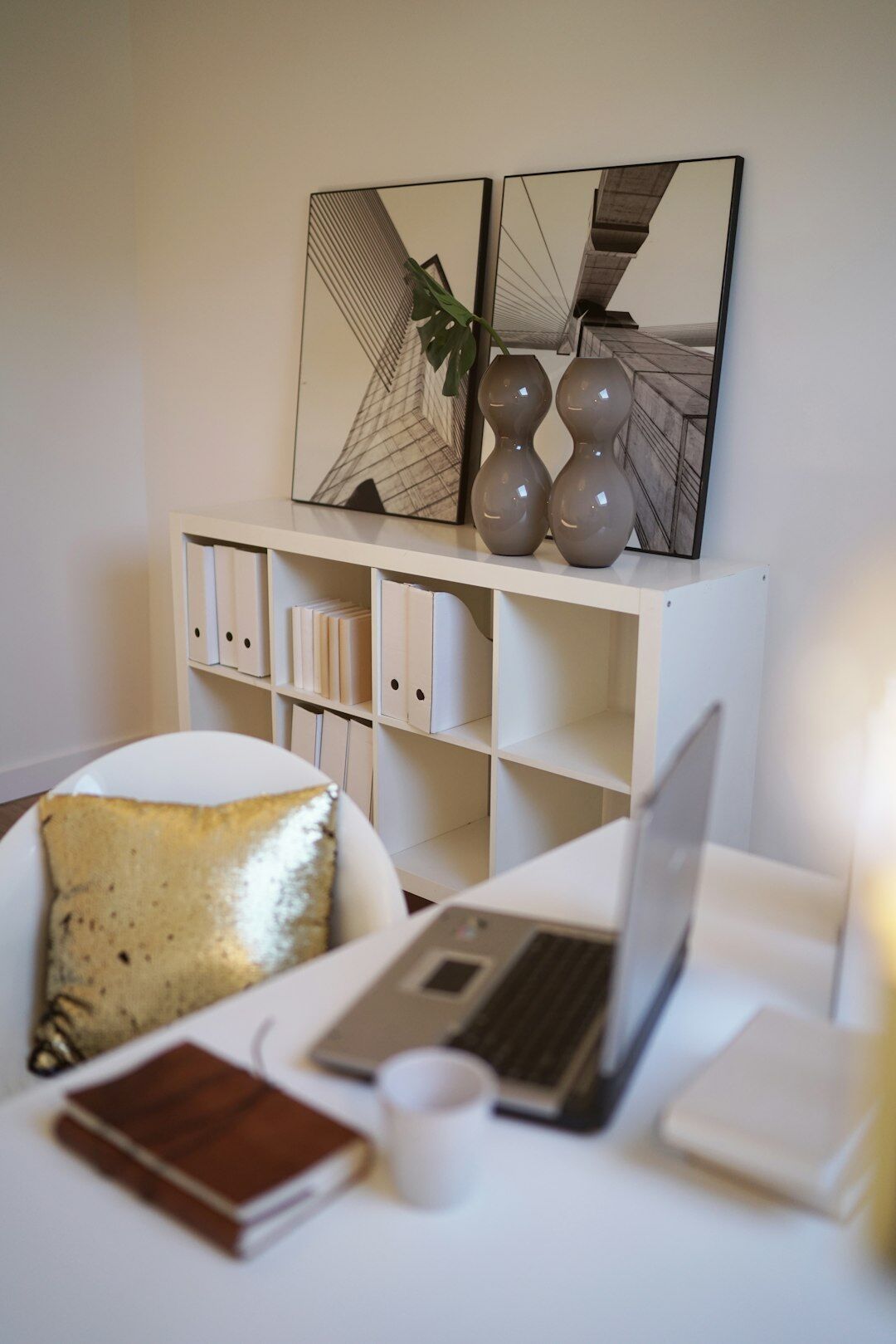 Laptop and old photographs on a wooden desk used to archive local stories